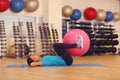 Woman doing exercises with pink fit ball in fitness gym class. Fitness ball helps women get a toned, tight stomach and strong core Royalty Free Stock Photo