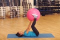 Woman doing exercises with pink fit ball in fitness gym class. Fitness ball helps women get a toned, tight stomach and strong core Royalty Free Stock Photo