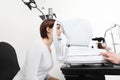 Woman doing eyesight measurement with optician slit lamp