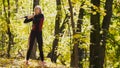 Woman doing fitness exercises outdoor. Female stretching her shoulders in autumn forest. Slim girl at work-out - the right side Royalty Free Stock Photo