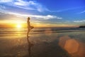 Woman doing fitness on the ocean beach during the amazing sunset. Royalty Free Stock Photo