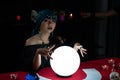 Woman doing fortune telling witchcraft forecasting the future with crystal ball and Tarot card on red table Royalty Free Stock Photo