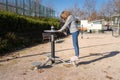 Woman doing gymnastics in a device in a public park for the improvement of physical form and health.