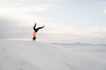 Woman doing a handstand at White Sands National Monument in Alamogordo, New Mexico.