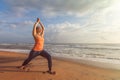 Woman doing yoga asana Virabhadrasana 1 Warrior Pose on beach on Royalty Free Stock Photo