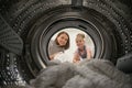 Woman Doing Laundry with her daughter Reaching towel Inside Washing Machine Royalty Free Stock Photo