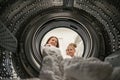 Woman Doing Laundry with her daughter Reaching towel Inside Washing Machine Royalty Free Stock Photo