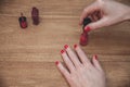 Woman Doing Manicure Applying Red Nail Polish. on wooden table Royalty Free Stock Photo