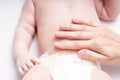 Woman doing massage against colic tummy to baby