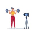 Woman doing Overhead barbell shoulder press exercise recording video with camera on tripod. Social network blogging, healthy