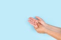Woman doing a palm hand self masage on a light blue background