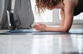 Woman doing plank pose at home during online training