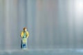 A woman doing safe solo shopping at supermarket wearing a face mask. Miniature people figurines toys conceptual photography