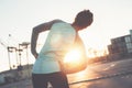 Woman doing side stretch exercise at sunset. Urban workout in industrial zone