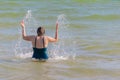 Woman doing splash wings of waving seawater