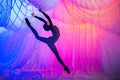 woman dances in a room with white curtains made of thin airy fabric, illuminated by blue and red spotlights Royalty Free Stock Photo