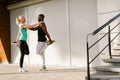 Woman doing stretching exercises with trainer during workout outdoors Royalty Free Stock Photo