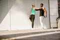 Woman doing stretching exercises with trainer during workout outdoors Royalty Free Stock Photo