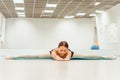 Woman doing stretching on the Mat in the hall sitting on the twine