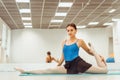 Woman doing stretching on the Mat in the hall sitting on the twine