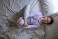 Woman doing sucirandhrasana or eye of the needle pose in yoga on bed