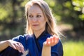 A girl doing tai Chi exercises in a green Park on a Sunny day close up Royalty Free Stock Photo