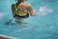 Woman Doing Water Aerobics in an Outdoor Swimming Pool: Rear View Royalty Free Stock Photo
