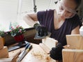 A woman doing wooden handicraft in the balcony Royalty Free Stock Photo