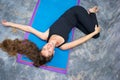 Woman doing yoga Ardha Jathara Parivarttanasa