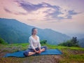 Woman doing yoga asana Baddha Konasana outdoors