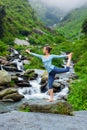 Woman doing yoga asana Natarajasana outdoors at waterfall Royalty Free Stock Photo