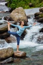 Woman doing yoga asana Natarajasana outdoors at waterfall Royalty Free Stock Photo