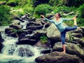Woman doing yoga asana Natarajasana outdoors at waterfall Royalty Free Stock Photo