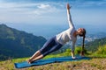 Woman doing yoga asana Vasisthasana - side plank pose outdoors