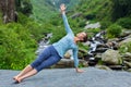 Woman doing yoga asana Vasisthasana - side plank pose outdoors Royalty Free Stock Photo