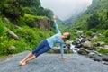 Woman doing yoga asana Vasisthasana - side plank pose outdoors