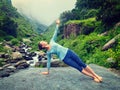 Woman doing yoga asana Vasisthasana - side plank pose outdoors Royalty Free Stock Photo