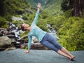 Woman doing yoga asana Vasisthasana - side plank pose outdoors Royalty Free Stock Photo