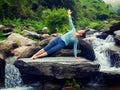 Woman doing yoga asana Vasisthasana - side plank pose outdoors Royalty Free Stock Photo