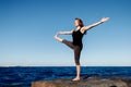 Woman doing yoga background blue sky and sea. Tree pose or vrksasana with hands together up above head. Concept Royalty Free Stock Photo