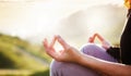 woman doing yoga in beautiful nature background at sunset or sunrise, focus on hand - mindfulness and mental health and hygiene Royalty Free Stock Photo