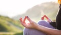 woman doing yoga in beautiful nature background at sunset or sunrise, focus on hand - mindfulness and mental health and hygiene Royalty Free Stock Photo