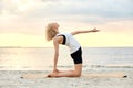 woman doing yoga camel pose on beach Royalty Free Stock Photo