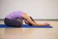 Woman doing yoga child pose on exercise mat