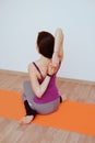 Woman doing yoga exercise on orange mat, stretching
