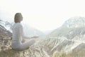 Woman doing yoga exercises over the top of a mountain