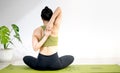 Woman doing yoga on the green yoga mat for meditite and excercise in the home Royalty Free Stock Photo