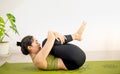 Woman doing yoga on the green yoga mat for meditite and excercise in the home Royalty Free Stock Photo