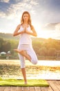 Woman doing yoga on the lake - beautiful lights Royalty Free Stock Photo