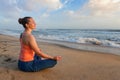 Woman doing yoga oudoors at beach - Padmasana lotus pose Royalty Free Stock Photo